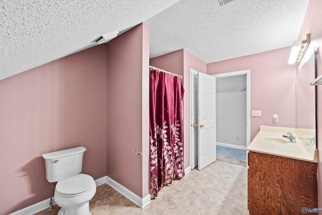 bathroom with vanity, toilet, and a textured ceiling