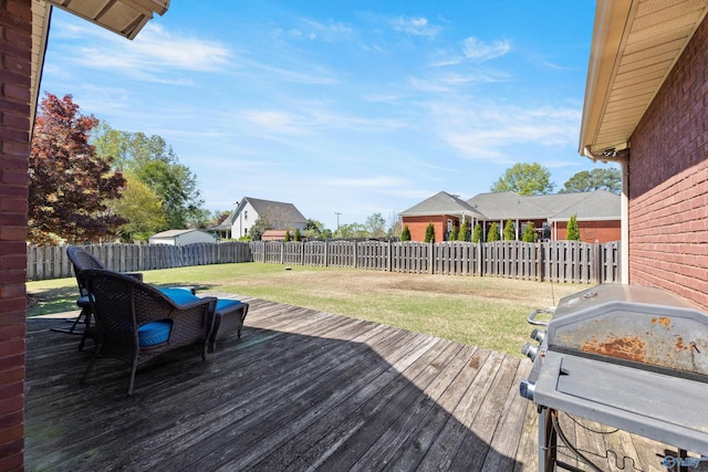 wooden terrace featuring a grill and a lawn