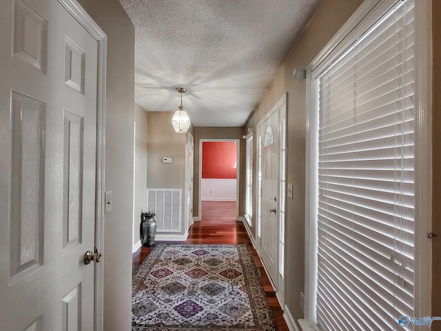 hallway featuring dark wood-type flooring and a textured ceiling