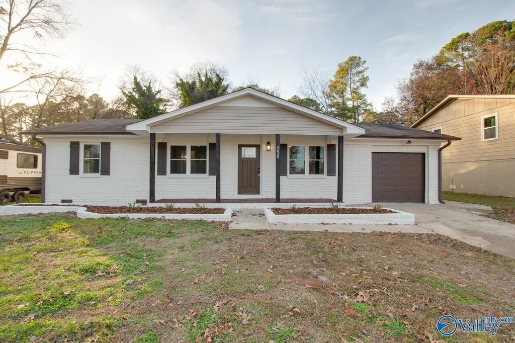 single story home with a garage, covered porch, and a front yard