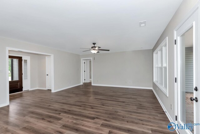 unfurnished living room featuring dark wood-type flooring and ceiling fan