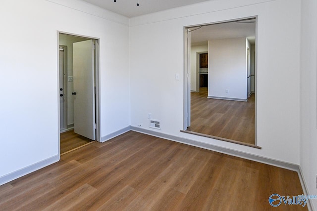 empty room with hardwood / wood-style flooring