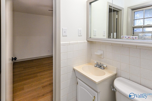 bathroom with vanity, hardwood / wood-style floors, toilet, and tile walls