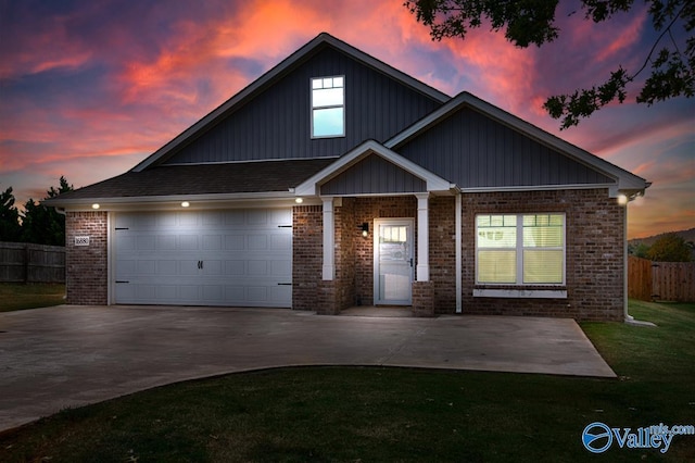 view of front of property with brick siding, a front yard, fence, a garage, and driveway