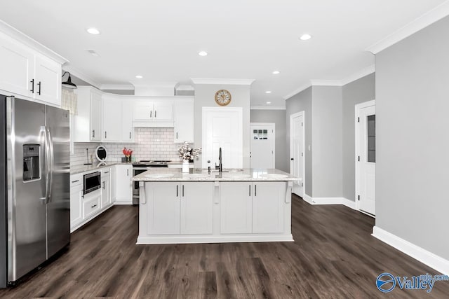 kitchen featuring white cabinets, light stone counters, appliances with stainless steel finishes, a sink, and backsplash