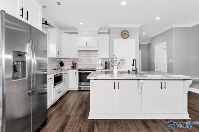 kitchen featuring visible vents, appliances with stainless steel finishes, dark wood-type flooring, a sink, and backsplash