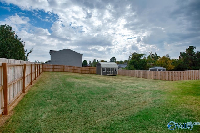 view of yard featuring a storage unit, an outdoor structure, and a fenced backyard