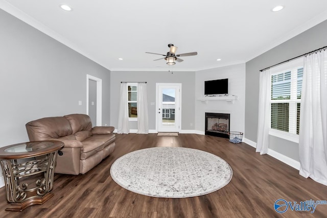 living area with recessed lighting, dark wood-style flooring, a fireplace, baseboards, and crown molding