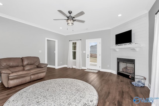 living room with ornamental molding, dark wood-type flooring, and baseboards