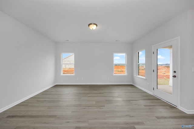 unfurnished room with a wealth of natural light and light hardwood / wood-style flooring