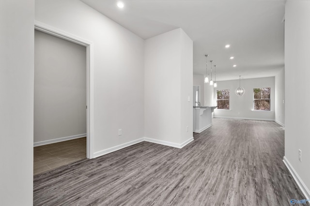 unfurnished room featuring a notable chandelier and hardwood / wood-style floors