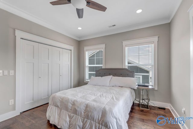 bedroom with dark wood-type flooring, ceiling fan, ornamental molding, and a closet