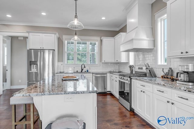 kitchen featuring premium range hood, stainless steel appliances, decorative backsplash, dark hardwood / wood-style floors, and a kitchen island