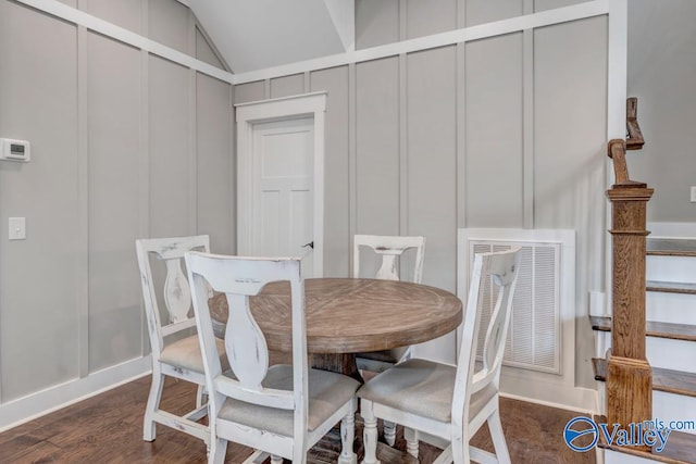 dining area with dark hardwood / wood-style flooring and vaulted ceiling