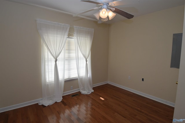 unfurnished room featuring ceiling fan, electric panel, and dark hardwood / wood-style flooring