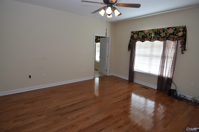 empty room with ceiling fan and dark wood-type flooring