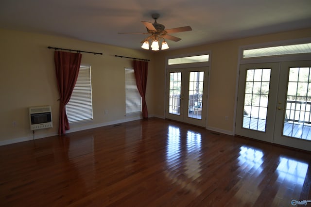 spare room featuring heating unit, french doors, dark hardwood / wood-style flooring, and ceiling fan