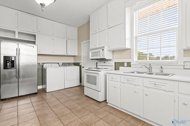 kitchen with white appliances, washing machine and clothes dryer, white cabinetry, open shelves, and a sink
