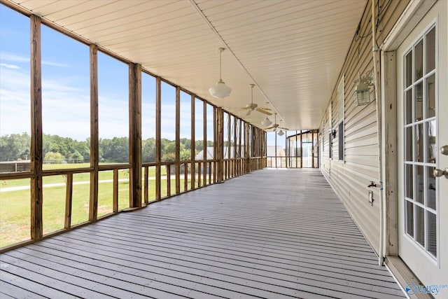 unfurnished sunroom with ceiling fan