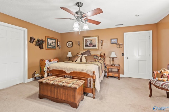 bedroom featuring baseboards, ceiling fan, visible vents, and light colored carpet