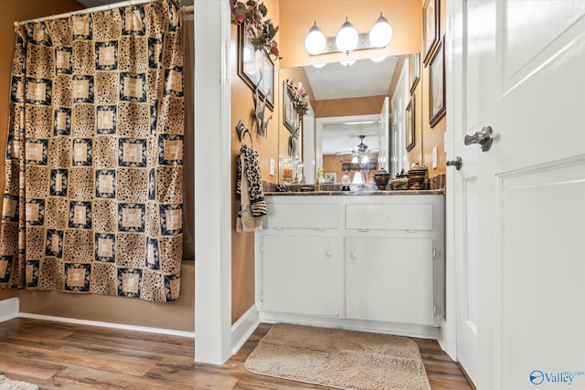 bathroom featuring a ceiling fan, a shower with curtain, vanity, and wood finished floors