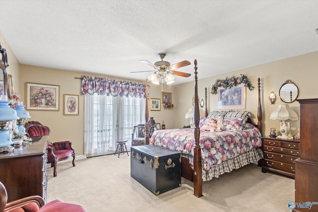 bedroom featuring light carpet, ceiling fan, and a textured ceiling