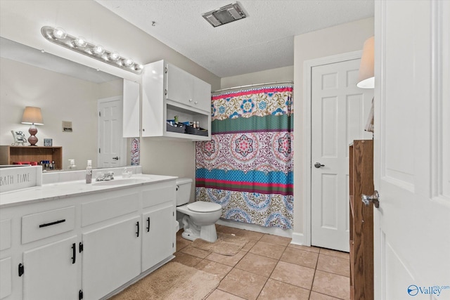 full bathroom with visible vents, toilet, tile patterned floors, a textured ceiling, and vanity