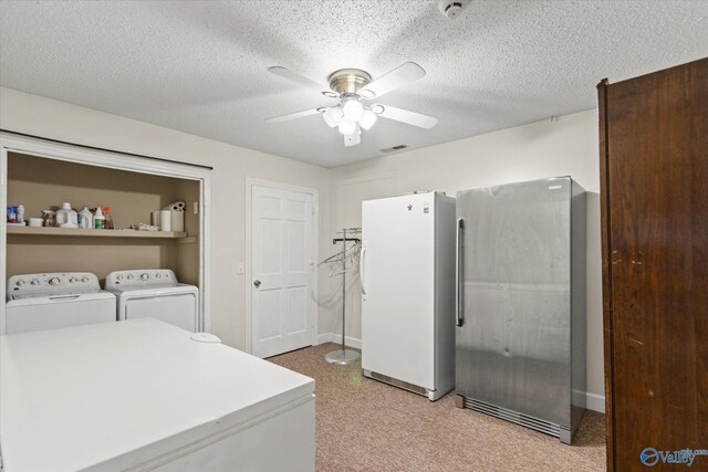 washroom featuring separate washer and dryer, light carpet, a textured ceiling, and ceiling fan