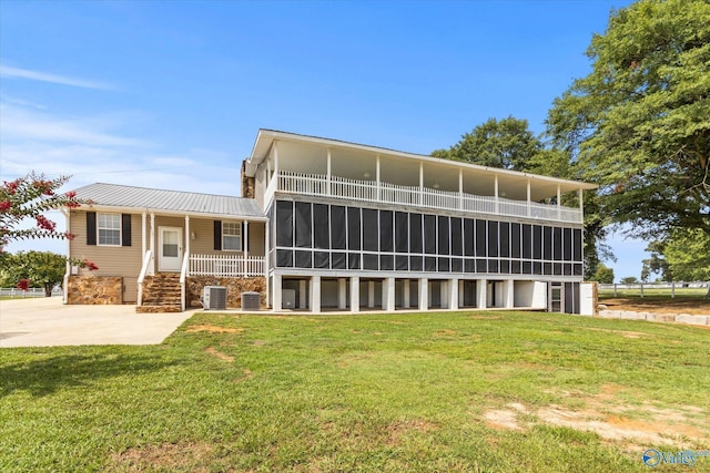 exterior space with metal roof, a lawn, and cooling unit