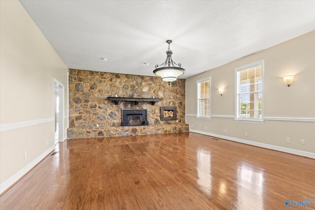 unfurnished living room featuring a textured ceiling, a fireplace, and hardwood / wood-style floors