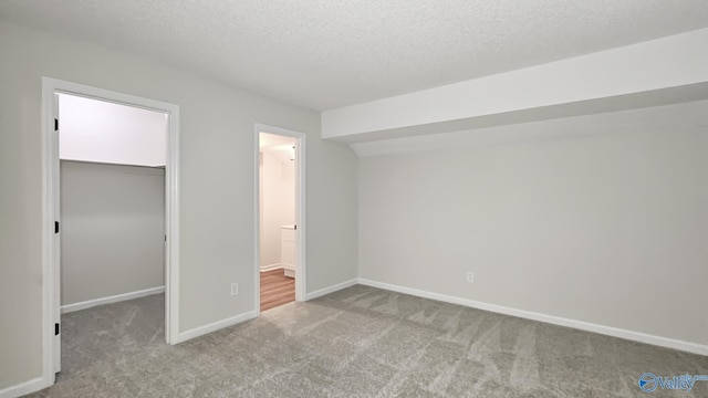 306 Autumn Ln, Madison, AL 35758 - unfurnished bedroom featuring a spacious closet, carpet, a closet, a textured ceiling, and ensuite bath