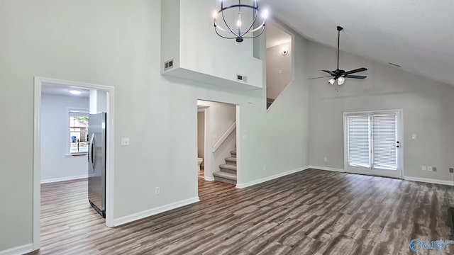 306 Autumn Ln, Madison, AL 35758 - unfurnished living room featuring high vaulted ceiling, dark wood finished floors, ceiling fan, stairs, and a chandelier