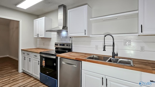 306 Autumn Ln, Madison, AL 35758 - kitchen featuring wooden counters, stainless steel appliances, wall chimney range hood, decorative backsplash, and white cabinetry