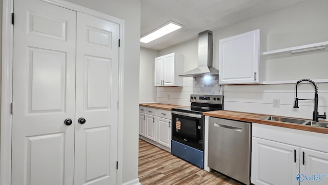 306 Autumn Ln, Madison, AL 35758 - kitchen with appliances with stainless steel finishes, wall chimney exhaust hood, butcher block counters, open shelves, and white cabinetry