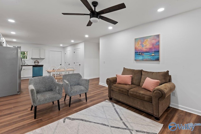 living room with ceiling fan and dark hardwood / wood-style flooring