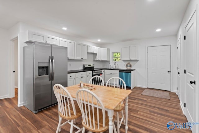 kitchen with sink, appliances with stainless steel finishes, dark hardwood / wood-style floors, and white cabinetry