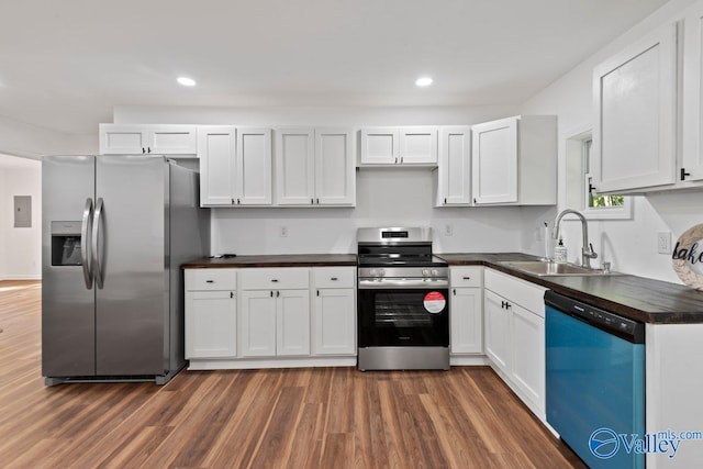 kitchen featuring appliances with stainless steel finishes, sink, dark hardwood / wood-style floors, and white cabinets