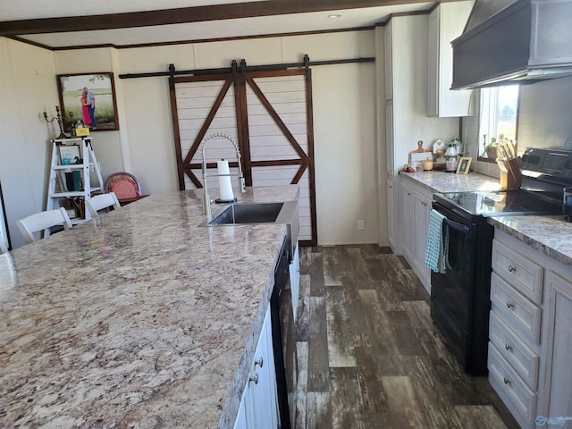 kitchen with custom exhaust hood, dark wood-style flooring, black electric range, a barn door, and a sink