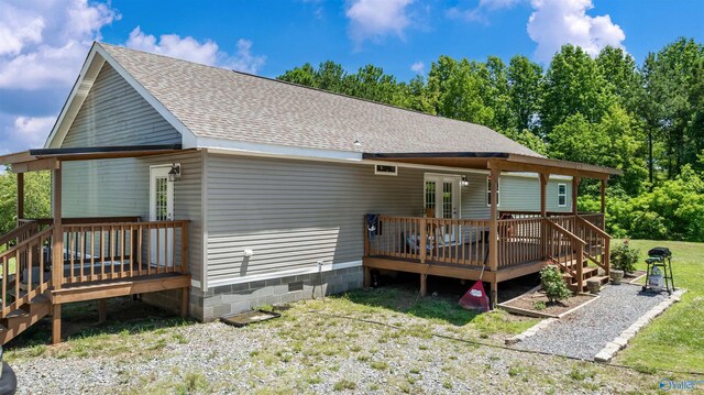 back of property with a deck and a lawn