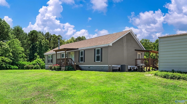 rear view of property featuring a yard and central AC unit