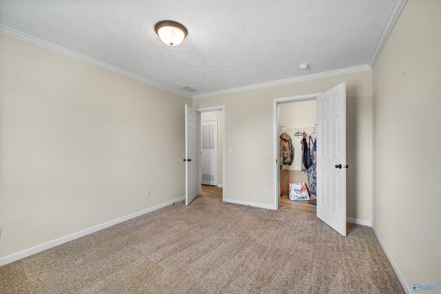 unfurnished bedroom with ornamental molding, carpet floors, and a textured ceiling