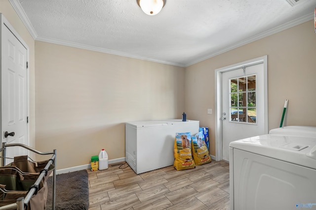 laundry area featuring ornamental molding, washer and clothes dryer, and a textured ceiling