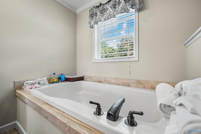 bathroom featuring ornamental molding and a tub to relax in