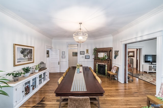 dining room with wood-type flooring, a chandelier, and ornamental molding