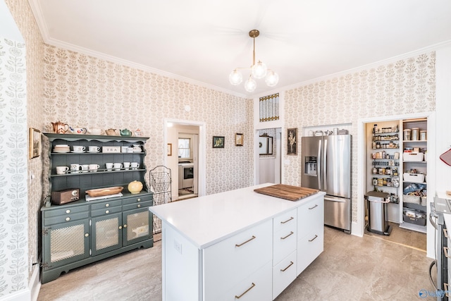 kitchen featuring ornamental molding, white cabinetry, stainless steel fridge with ice dispenser, wallpapered walls, and a chandelier