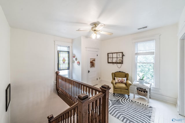 interior space with visible vents, baseboards, wood finished floors, and a ceiling fan