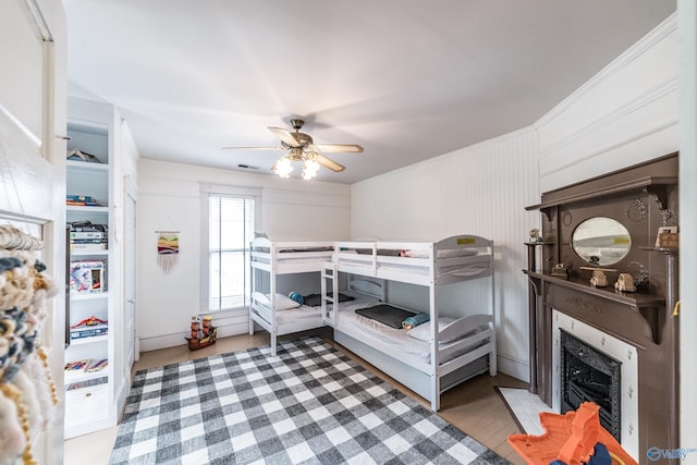 bedroom featuring a fireplace with flush hearth, a ceiling fan, and visible vents