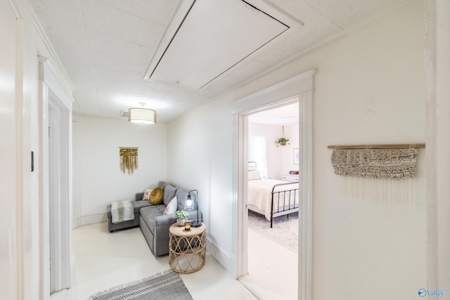 living area featuring baseboards and attic access