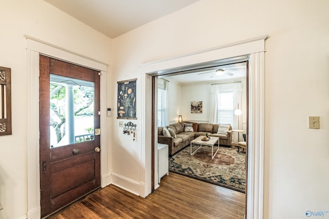 entrance foyer with dark wood finished floors, a ceiling fan, and baseboards