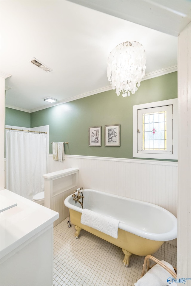 bathroom featuring tile patterned floors, ornamental molding, a chandelier, and a tub